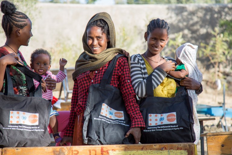 [PHOTO shows women in Ethiopia’s Tigray region receiving UNFPA dignity kits. PHOTO CREDIT: UNPFA Ethiopia.]